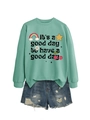 Mise à plat du sweat vert menthe avec imprimé arc-en-ciel et mini-short en jean déchiré - Sweat-shirt Vert Clair (Texte Noir)