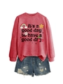 Détail d'un sweat rouge avec motif arc-en-ciel et un short en jean délavé - Sweat-shirt Rouge (Texte Noir)
