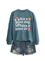 Mise à plat d'un sweat bleu avec imprimés arc-en-ciel et mini-short en jean usé - Sweat-shirt Bleu (Texte Blanc)