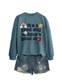 Gros plan d'un sweat bleu avec motifs arc-en-ciel et mini short en jean déchiré - Sweat-shirt Bleu (Texte Noir)