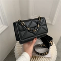 Quilted black crossbody bag featuring a chain handle and branded fabric shoulder strap - Black