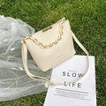 Cream white chain bucket bag with adjustable shoulder strap on green grass - White