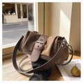 Gros plan du sac à bandoulière en suède marron avec boucle rétro et plis texturés - Marron