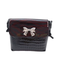 Close-up of black croc-effect bag with red zebra flap and silver bow buckle detail - Red Zebra Print