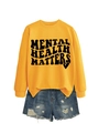 Close-up of yellow 'Mental Health Matters' sweatshirt paired with distressed denim shorts - Yellow (Black Font)