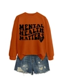 Detail of Mental Health Matters slogan printed on an orange crewneck sweatshirt - Burnt Orange (Black Font)