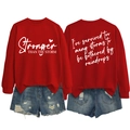 Dettaglio della felpa rossa con stampa Stronger than the Storm e testo sul retro capo - S / Carattere Bianco / Rosso