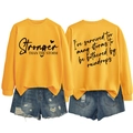 Front and back detail of yellow long sleeve sweatshirt with Stronger than the Storm print - S / Black Font / Yellow