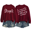 Detail view of burgundy sweatshirt with Stronger Than The Storm print and ribbed cuffs - S / White Font / Burgundy