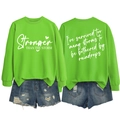 Flat lay of neon green Stronger Than The Storm sweatshirt with ripped denim shorts - S / White Font / Fluorescent Green