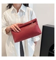 Close-up of wine red woven leather clutch bag with elegant texture and metal buckle - Red