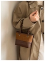 Detailaufnahme der Vintage Beuteltasche mit zweifarbig braunen Texturen und Ösen - Braun