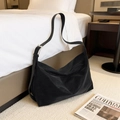 Minimalistische zwarte suède hobo schoudertas met verstelbare riem op wit beddengoed - Zwart