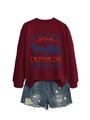 Detail view of burgundy crewneck sweatshirt with retro carriage print and ripped denim shorts - Burgundy