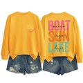 Flat lay of yellow Lake Days sweatshirt and denim shorts with detailed back graphic print - Yellow-Black Text Print