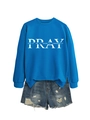 Detail of blue crewneck sweatshirt with PRAY lettering and ripped denim shorts - Lake Blue (White Font)