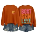 Detailed back view of Boat Sun Lake printed orange sweatshirt and ripped denim shorts - Burnt Orange-Black Text Print