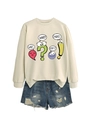 Flat lay of a beige sweatshirt with cartoon graphics paired with distressed denim shorts - Sand
