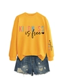 Détail du sweat jaune 'Kindness is Free' avec impression manche et short en jean déchiré - Jaune (Impression Noire)