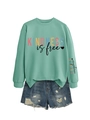 Mise à plat de sweat vert menthe Kindness is Free avec un short en jean bleu délavé - Vert Clair (Impression Noire)