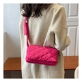 Hot pink quilted nylon crossbody bag shown worn by a model in a minimalist setting - Rose Red