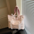 Bolso tote rosa de lunares con encaje blanco y lazo sobre una silla de cuero negro - Rosa