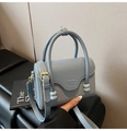 Grayish blue crossbody bag featuring a unique spliced texture and top circular handle - Blue