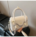Detail of a creamy white mini handbag featuring woven leather textures and a metal logo - White