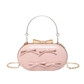 Pochette de soirée ovale rose avec détails nœuds et bandoulière chaîne dorée vue 45° - Rose
