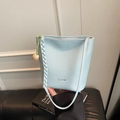 Retro light blue bucket bag with pebble leather texture and a wooden bead charm - Blue