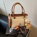 Chic cream woven bucket bag with brown leather trim and a cute plush bear charm - Brown With Bear Pendant