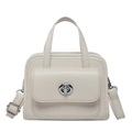 Elegante cremeweiße Handtasche aus Kunstleder mit silbernem Drehverschluss im Detail - Weiß