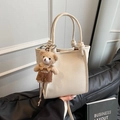 Borsa a secchiello in pelle crema con trama litchi e un simpatico ciondolo a orsetto - Con Ciondolo / Bianco Sporco