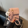 Pink minimalist crossbody square bag with glossy leather finish and plush ball charm - With Charm / Pink