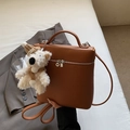 Bolso de cuero granulado marrón caramelo con charm de osito en cama blanca - Marrón con Colgante