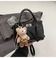 Detail of black matte handbag featuring silver twist lock and plush bear bag charm - Black With Pendant