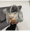 Detail of silver leather handbag with a plush bear charm and mini envelope pouch - Silver with Charm