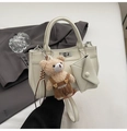 Detail of cream white PU leather tote with metal twist lock, teddy bear and pouch - White With Pendant