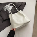 Glossy white tote bag for women placed on a dark blazer for a stylish commuter look - No Pendant / White