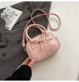 Dettaglio di una mini borsa da bowling rosa con fiocco su uno sfondo minimalista - Rosa Senza Pendente