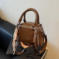 Brown mini pillow bag in shiny leather with white stitching and woven knot charm - Brown (With Pendant)