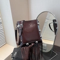 Dark brown bucket bag with shiny patent leather, silver rivets, and long fringe details - Brown