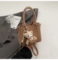 Detailansicht der kamelfarbenen Eimer-Tasche mit Lychee-Muster und Teddybär-Anhänger - Mit Ornament / Khaki