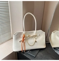Detail of cream white tote bag with gold chain heart pendant and woven strap charms - White with Pendant