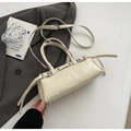 Creamy leather Boston handbag with metal eyelet straps in a stylish lifestyle setting - Off-White (Without Pendant)