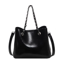 Minimalistische schwarze glänzende Beuteltasche mit Kettenhenkel und Lederriemen - Schwarz