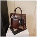 Macro detail of glossy brown vintage faux leather texture and reinforced handbag handle - With Charm / Coffee