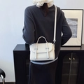 Crèmewitte crossbodytas van geplooid leer met zilveren gespen in lifestyle setting - Off-wit