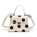 Chic beige crossbody bag with bold black polka dots and metallic twist lock closure - White