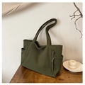 Detalle de bolso tote de pana verde que muestra la textura de canalé y bolsillo lateral - Verde